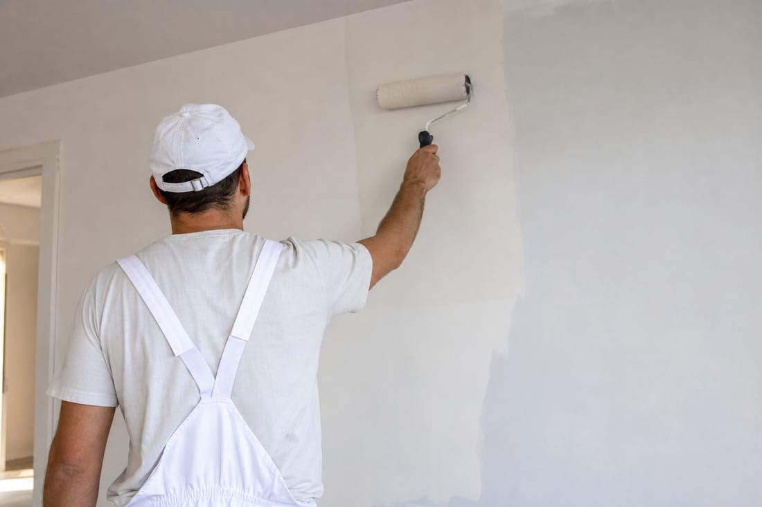 Beispiel: Maler mit Rolle an der Wand, von hinten